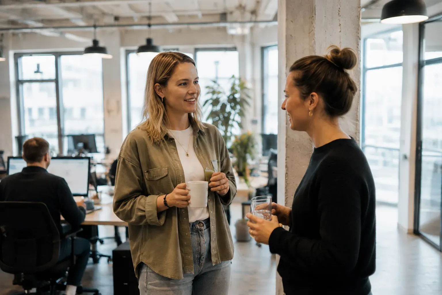 Two colleagues with coffee during a relaxed monthly check-in on a running MCP server