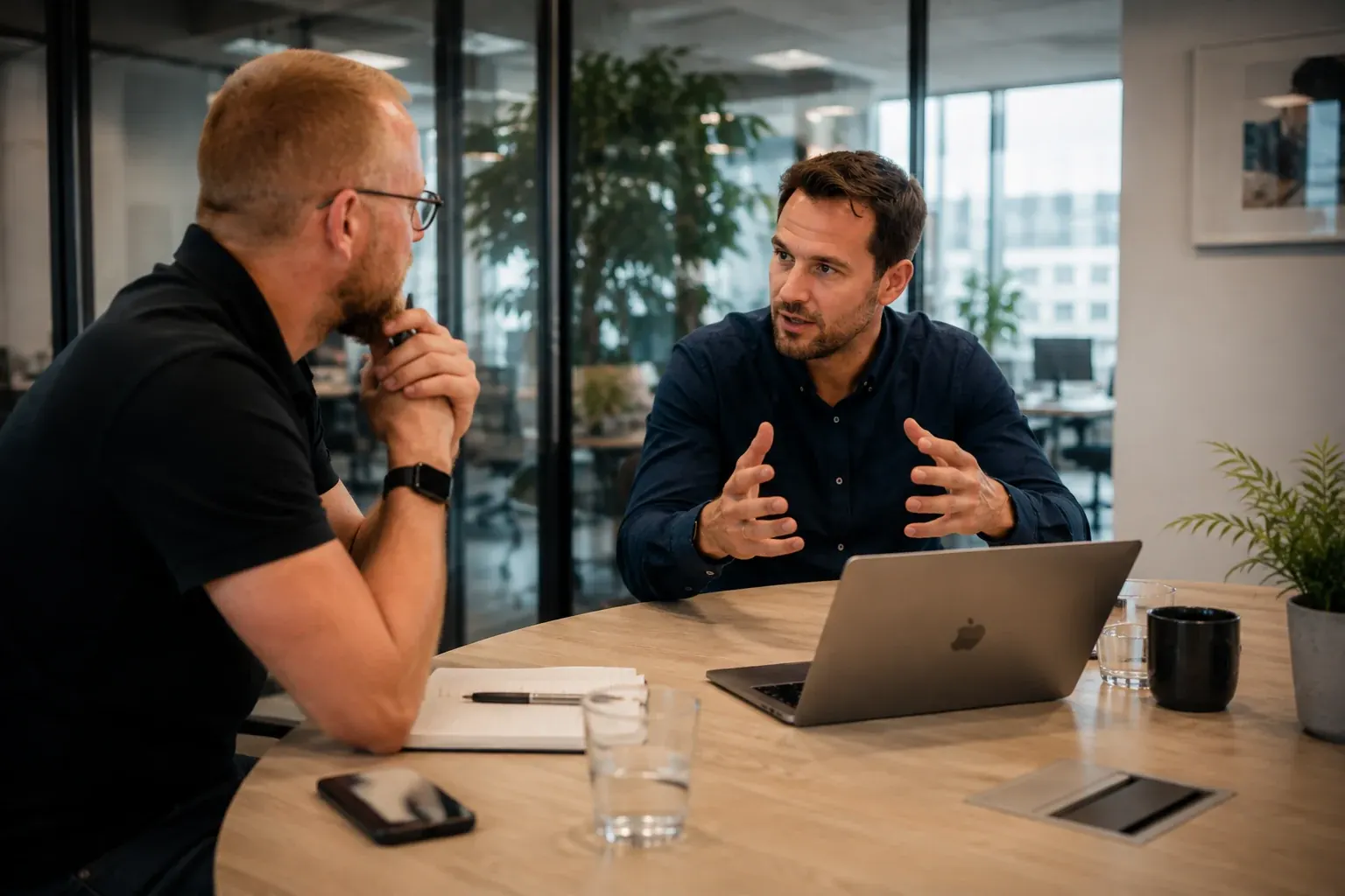 Two people in conversation at a laptop during the kickoff of an MCP server build